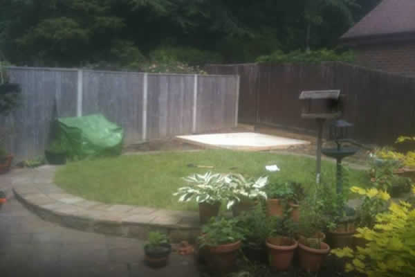 Before: a small lawn with a fence and pots