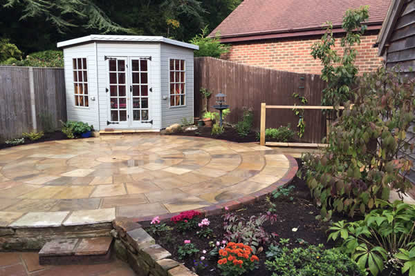 The finished garden: the summer house, circular paving and a raised planted border