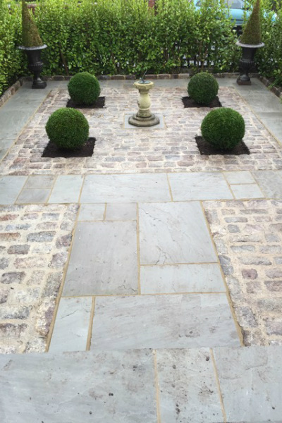 Stone paving with setts, clipped box balls and a sundial